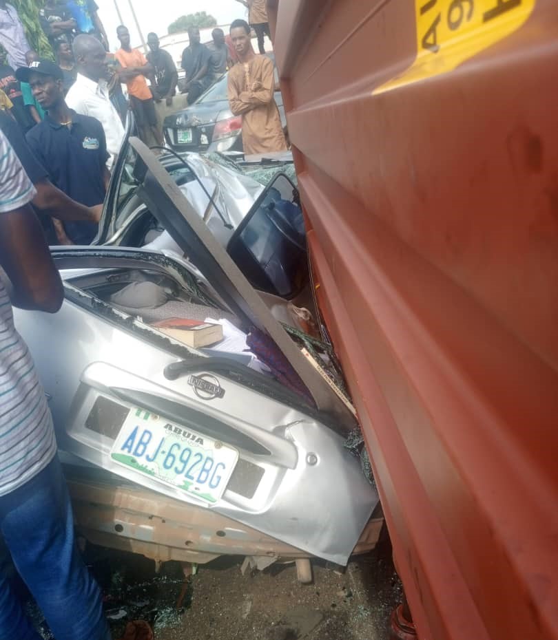 ONE DIES, DRIVER ESCAPES, AS CONTAINER FALLS ON CAR